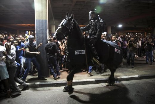 Protesters, whom are mainly Israeli Jews of Ethiopian origin, run away as a policeman on a horse tries to disperse them during a demonstration against what they say is police racism and brutality, after the emergence last week of a video clip that showed policemen shoving and punching a black soldier in a protest at Rabin Square in Tel Aviv May 3, 2015. Israeli mounted police charged hundreds of ethnic Ethiopian citizens and fired stun grenades on Saturday to try to clear one of the most violent protests in memory in the heart of Tel Aviv. REUTERS/Baz Ratner - RTX1BDSA