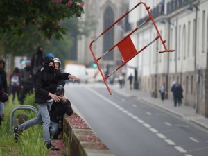 A protestor throws a piece of fence as demonstrators march on May 17, 2016 in Nantes, western France, to protest against the government's planned labour law reforms. Incidents between protestors and police forces escalated around 12h00 in Nantes during a protest against planned employment and labour law reform, during which between 3,500 and 10,000 individuals took part, according to sources. / AFP PHOTO / JEAN-SEBASTIEN EVRARD