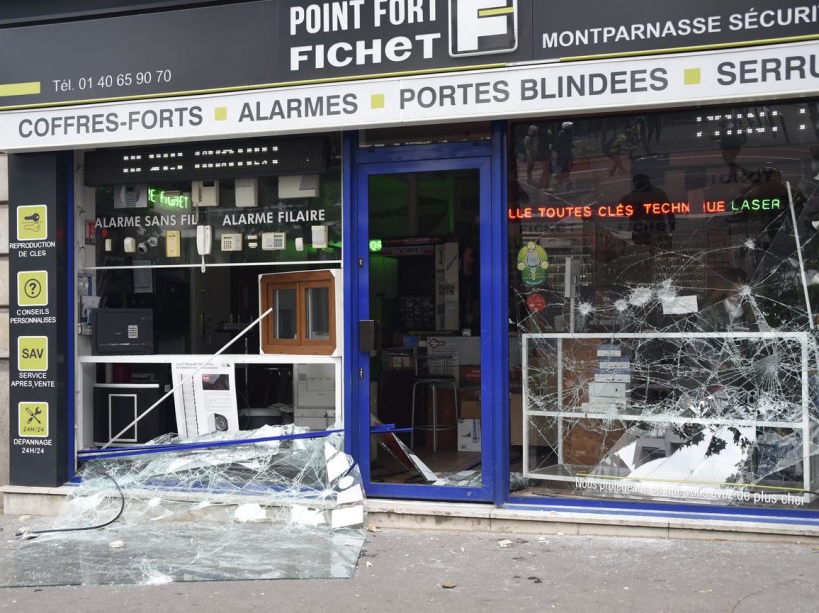 A photo taken on June 14, 2016 shows the broken window of a shop during a demonstration against proposed labour reforms in Paris. Several hundred masked protesters hurled objects at police on June 14 during a demonstration in Paris against a contested reform of French labour laws, authorities said. / AFP PHOTO / DOMINIQUE FAGET