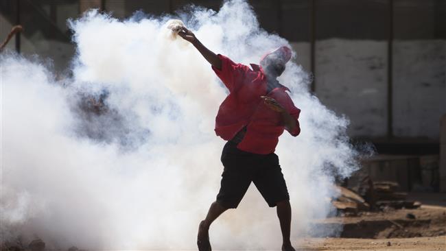 Protester hurls teargas canister back at riot pigs