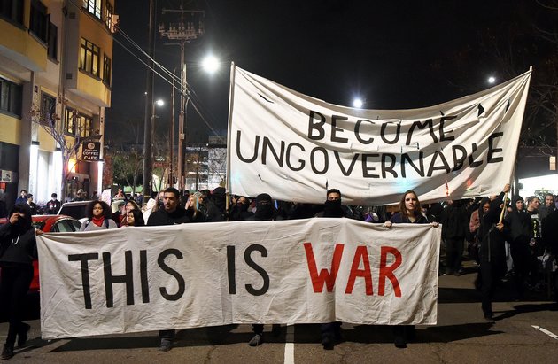 Protesters march with signs in Berkeley, California on February 1, 2017. Violent protests erupted on February 1 at the University of California at Berkeley over the scheduled appearance of a controversial editor of the conservative news website Breitbart. / AFP / Josh Edelson (Photo credit should read JOSH EDELSON/AFP/Getty Images)